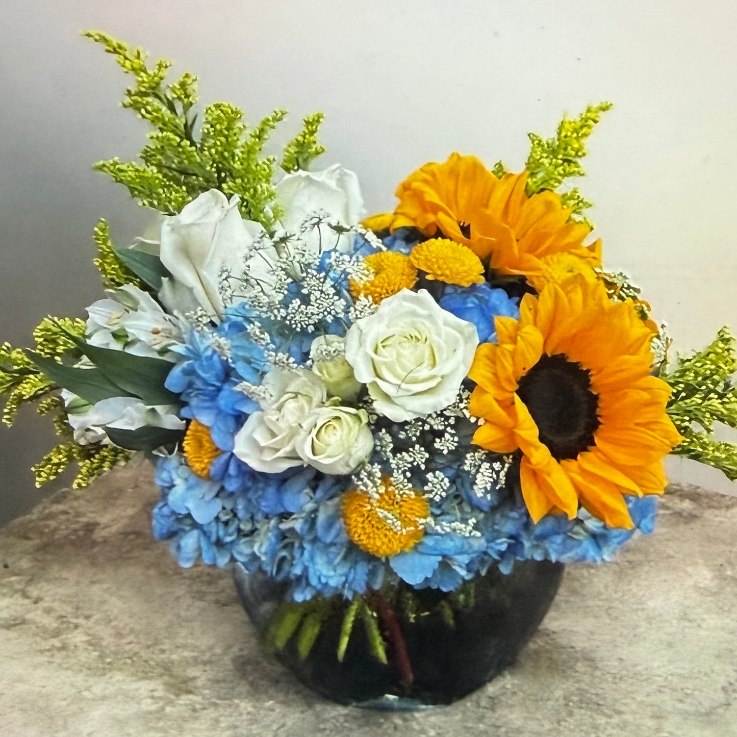 Sunflowers, Blue Hydrangea, White Spray Roses & Solidago Arrangement In A Vase